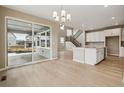 Open-concept living room featuring hardwood floors, a kitchen island, and sliding glass doors at 39751 Congress Ln, Elizabeth, CO 80107