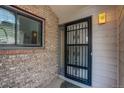 Inviting front entry featuring a secure iron gate, brick accents, and a stylish exterior light fixture at 11186 E Baltic Dr, Aurora, CO 80014