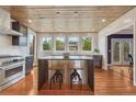 Bright kitchen with wooden ceiling, stainless appliances, center island, and hardwood floors at 1590 S Milwaukee St, Denver, CO 80210