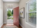 Bright foyer with hardwood floors, a red door, and stylish decor at 817 Uinta Way, Denver, CO 80230