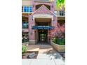 Street view of a condo entrance showcasing brickwork, a covered entryway, and manicured landscaping at 1100 N Grant St # 208, Denver, CO 80203