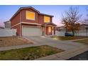 Charming home featuring stucco exterior, tiled roof, two-car garage, and a welcoming covered front porch at 5552 Flanders Way, Denver, CO 80249