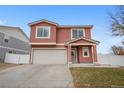 Charming home featuring stucco exterior, tiled roof, two-car garage, and a welcoming covered front porch at 5552 Flanders Way, Denver, CO 80249