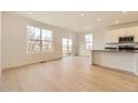 Modern kitchen with white cabinets, island, and stainless steel appliances at 261 Paloma Way, Elizabeth, CO 80107