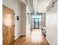 Bright hallway with hardwood floors, white walls, modern accents, and large windows for natural light at 3100 Huron St # 3E, Denver, CO 80202
