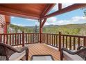 Relaxing covered wood deck featuring log beams and scenic mountain views at 29477 Blue Moon Dr, Evergreen, CO 80439