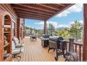 Inviting wooden deck with grilling area perfect for entertaining and enjoying mountain views at 29477 Blue Moon Dr, Evergreen, CO 80439