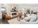 Inviting living room featuring a modern fireplace, hardwood floors, and stylish furnishings at 10295 E 59Th Ave, Denver, CO 80238