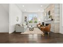 Bright living room showcasing hardwood floors, a stylish fireplace, and comfortable seating at 10295 E 59Th Ave, Denver, CO 80238