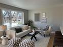 Comfortable living room featuring a neutral color palette and ample natural light from a large window at 2521 Billings St, Aurora, CO 80011