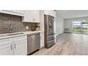 Modern kitchen features stainless steel appliances and white shaker cabinets at 715 S Alton Way # 5A, Denver, CO 80247