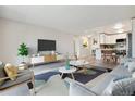Open concept living room with kitchen view, stylish furniture, and hardwood floors at 715 S Alton Way # 5A, Denver, CO 80247