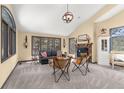 Bright living room featuring a stone fireplace, vaulted ceiling, and views of the surrounding trees at 7395 Heiter Hill Dr, Evergreen, CO 80439