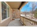 Covered front porch with stonework, offering a relaxing outdoor space at 3008 Mountain Sky Dr, Castle Rock, CO 80104