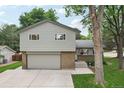 Two story home featuring brick accents, a gray front door, garage, and front walkway at 6514 Zinnia St, Arvada, CO 80004