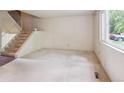 Bright living room features a staircase, large window, and neutral carpeting at 372 Vance St, Lakewood, CO 80226
