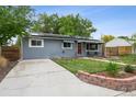 Neat front yard with green grass, a paved driveway, and an inviting exterior with garden bed at 3930 S Hazel Ct, Englewood, CO 80110
