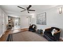 Open concept living area with hardwood floors, black arm chairs, a ceiling fan, and seamless access to kitchen at 3930 S Hazel Ct, Englewood, CO 80110