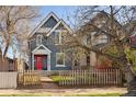 Charming two-story home with a red door, quaint picket fence, and well-manicured lawn at 3142 W 26Th Ave, Denver, CO 80211