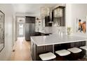 Modern kitchen with dark cabinetry, a white quartz countertop, and stylish bar stool seating at 3142 W 26Th Ave, Denver, CO 80211