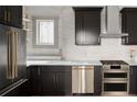 Modern kitchen features sleek black cabinets, stainless steel appliances, and a bright window at 3142 W 26Th Ave, Denver, CO 80211