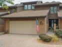 Townhome exterior featuring a two-car garage and American flag at 5845 W Mansfield Ave # 259, Denver, CO 80235