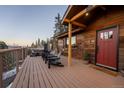 Relaxing outdoor deck with a hot tub, comfortable seating, and scenic mountain views, ideal for entertaining at 32094 Christopher Ln, Conifer, CO 80433
