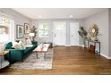 Bright living room with hardwood floors, green sofa, large windows, and contemporary decor at 3320 N Madison St, Denver, CO 80205