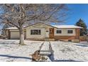 Ranch style home with brick and siding accents, snow covered yard at 994 S Vivian Ct, Lakewood, CO 80228