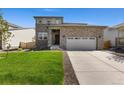 Charming two-story home featuring a stone facade and a well-manicured lawn at 6150 Sugarloaf St, Brighton, CO 80601