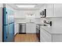 Bright kitchen featuring white cabinets, marble countertops, stainless steel appliances, and wood-look flooring at 9050 Zephyr Ct, Broomfield, CO 80021