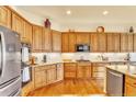 Spacious kitchen with wood cabinets, granite countertops, stainless steel appliances, and hardwood flooring at 501 Young Cir, Castle Rock, CO 80104