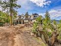 Charming mountain home with blue trim, stone accents, mature pines and natural landscaping at 24354 Eagle Cliff Trl, Conifer, CO 80433