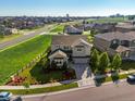 Wonderful neighborhood view showcasing a beautiful home with a well-maintained yard, landscaping, and stone accents at 1291 Fountain Ln, Erie, CO 80516