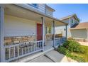 Close up of covered front porch with stone accents and nice landscaping at 13265 Raritan St, Denver, CO 80234