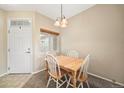 Dining room with a wooden table, four chairs, and a view of the outside at 228 Quari St, Aurora, CO 80011