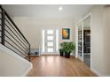 Inviting foyer with hardwood floors, a modern staircase, and a view into an office space at 2136 S Juniper St, Lakewood, CO 80228