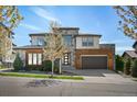 Two-story home featuring a stone and wood facade, a two-car garage, and professional landscaping at 2136 S Juniper St, Lakewood, CO 80228