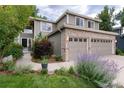 Well-maintained home with a two-car garage, beautiful landscaping, and a welcoming walkway leading to the front door at 9170 Fox Fire Dr, Highlands Ranch, CO 80129