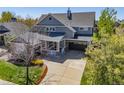 A charming two-story house boasts beautiful landscaping, gray siding, stone accents, and a two-car garage at 4119 Riley Dr, Longmont, CO 80503