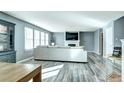 Spacious living room featuring a fireplace, large windows, and sleek wood floors at 1130 Cardinal Ave, Brighton, CO 80601