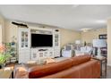Inviting living room with a white entertainment center, comfortable seating, and a decorative brown leather sofa at 7040 E Girard Ave # 406, Denver, CO 80224