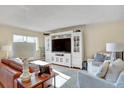Bright living room featuring a large entertainment center, comfortable seating, and natural light from the window at 7040 E Girard Ave # 406, Denver, CO 80224