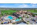 Stunning aerial view of the community clubhouse, pool, and well-manicured golf course under a bright blue sky at 7790 S Queensburg Way, Aurora, CO 80016