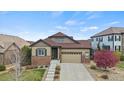 Charming single-Gathering home with brick accents, a well-manicured lawn, and a two-car garage at 7790 S Queensburg Way, Aurora, CO 80016