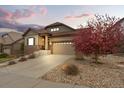 Beautifully landscaped front yard with a stone driveway leading to the attached two-car garage at 7790 S Queensburg Way, Aurora, CO 80016