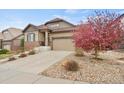 Beautifully landscaped front yard with a stone driveway leading to the attached two-car garage at 7790 S Queensburg Way, Aurora, CO 80016