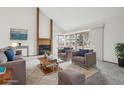 Bright living room features a fireplace, vaulted ceiling, and large windows at 11285 Ranch Pl, Denver, CO 80234