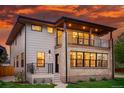Beautiful two-story home with a brick facade and balconies, perfect for enjoying the colorful evening sky at 2391 Hudson St, Denver, CO 80207