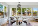 Bright living room featuring large windows with neighborhood views, accent chairs, and modern decor at 2391 Hudson St, Denver, CO 80207